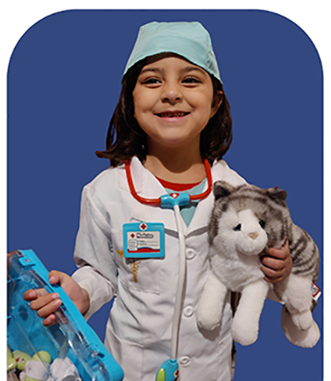 Girl dressed as a veterinarian holding a stuffed animal
